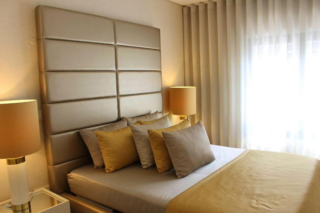 1 dormitorio con 1 cama grande y 2 lámparas en 2 bedrooms apartement with shared pool and wifi at Lisbon, en Lisboa