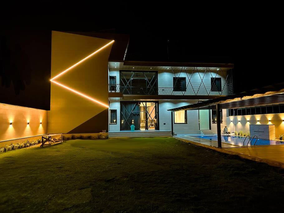 un grande edificio con un cortile illuminato di notte di Grazio Outhouse By The Party Citadel a Dahmi
