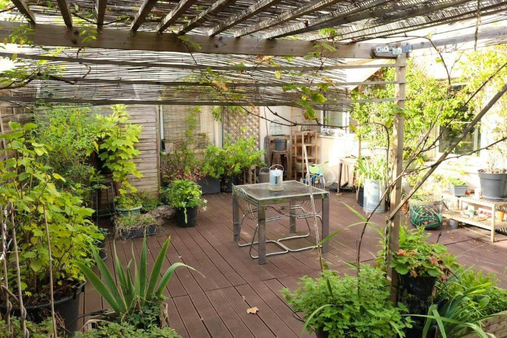ein Gewächshaus mit einem Tisch und vielen Pflanzen in der Unterkunft Appartement de 2 chambres avec terrasse et wifi a Bagnolet in Bagnolet