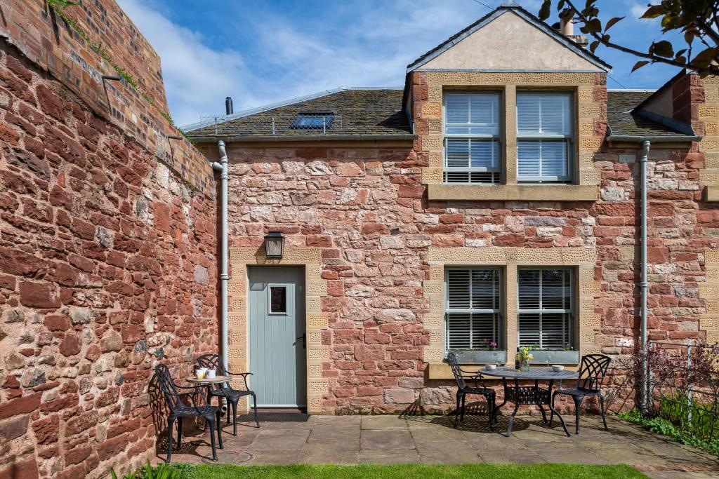 a brick building with a table and chairs at The Tackhouse in Greenlaw