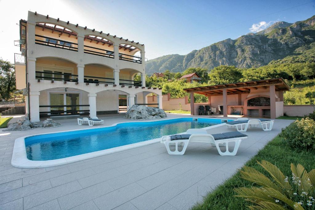 une maison avec une piscine en face d'un bâtiment dans l'établissement Villa Milena, à Herceg-Novi