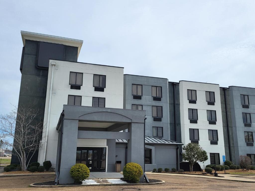 a large white building with an arch in front of it at Travel Inn-Flowood in Flowood