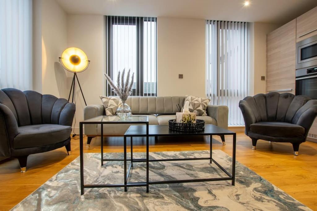 een woonkamer met een bank en 2 stoelen bij Luxury City Centre Apartment (Weekly Booking) in Hull