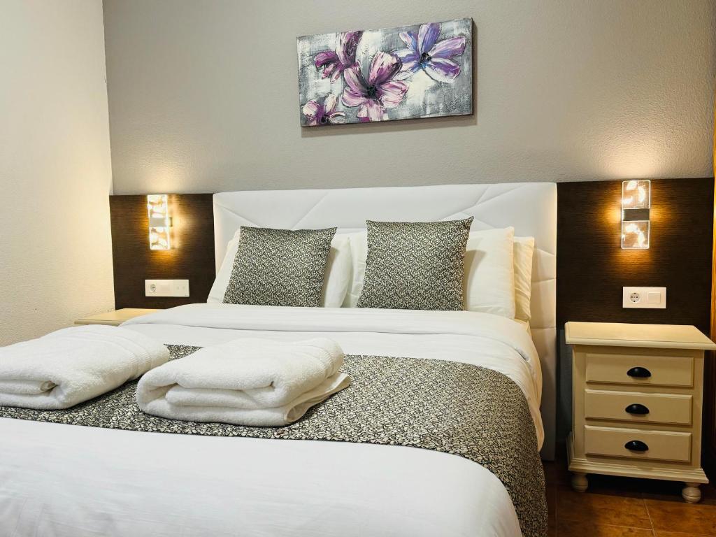 um quarto com 2 camas e almofadas brancas em Ballestar Hotel Bar & Grill em Barajas de Melo