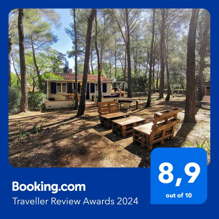 une maison avec une table de pique-nique et des bancs dans une cour dans l'établissement Maisonnette en pleine nature, au Beausset