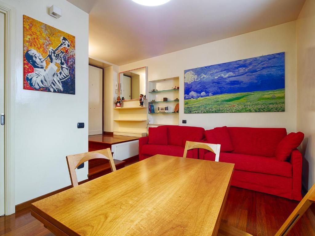 羅馬的住宿－鬥獸場甜蜜之家公寓，客厅配有红色的沙发和木桌