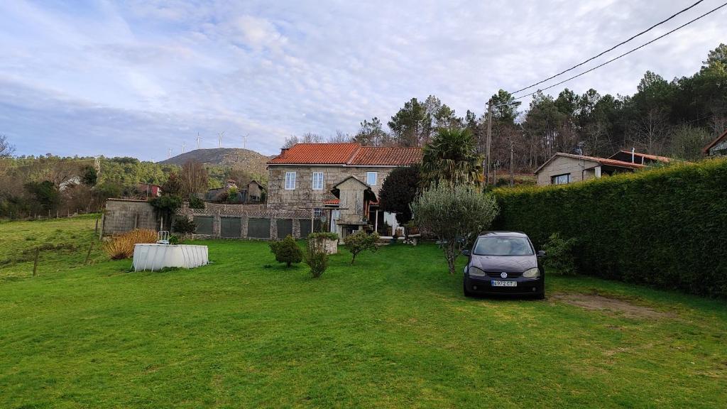 ein Auto, das im Hof eines Hauses geparkt ist in der Unterkunft A Leiriña - Casa rural para desconexión in La Cañiza