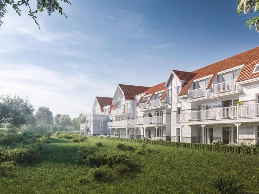 une rangée d'immeubles d'appartements avec une cour verdoyante dans l'établissement Vagues d'Opale, à Camiers