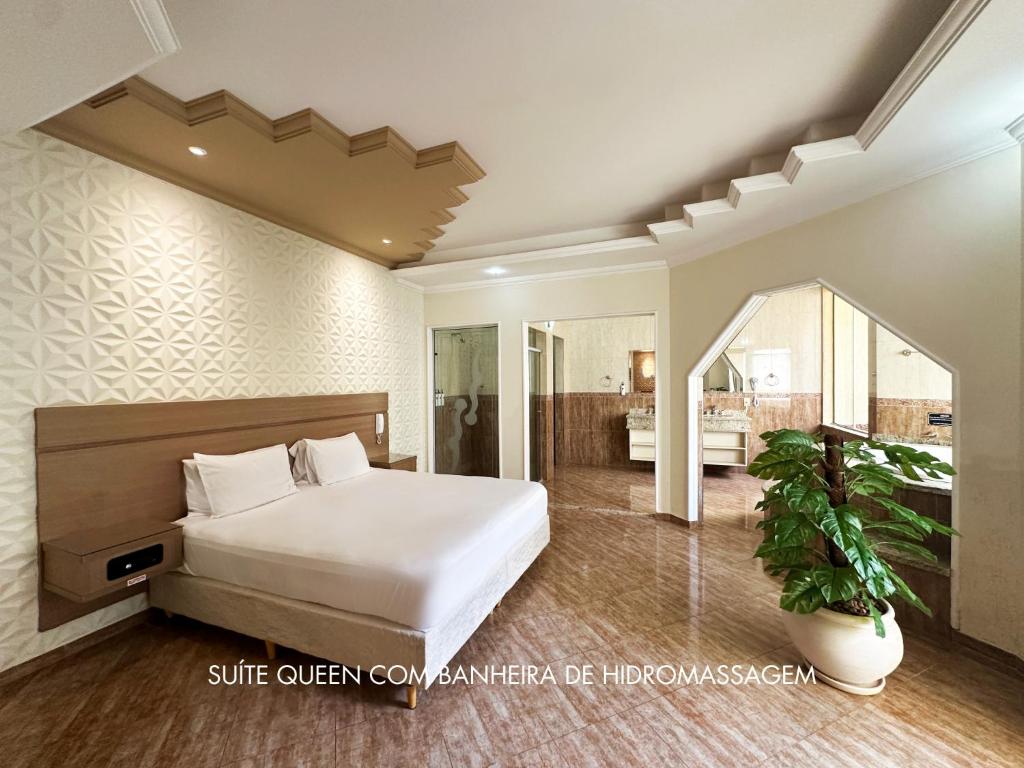 1 Schlafzimmer mit einem großen Bett und einem Badezimmer in der Unterkunft Motel Haraam in Araraquara