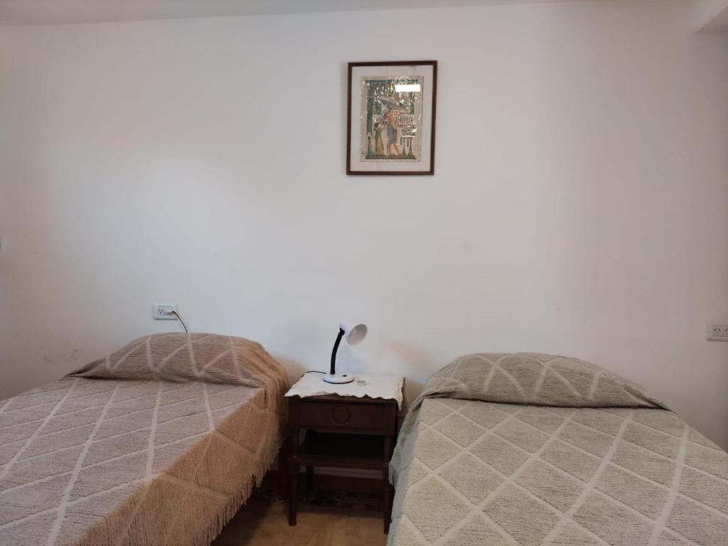 ein Schlafzimmer mit 2 Betten und einem Tisch mit einer Lampe in der Unterkunft MELMAR - Habitación triple con baño privado in Godoy Cruz