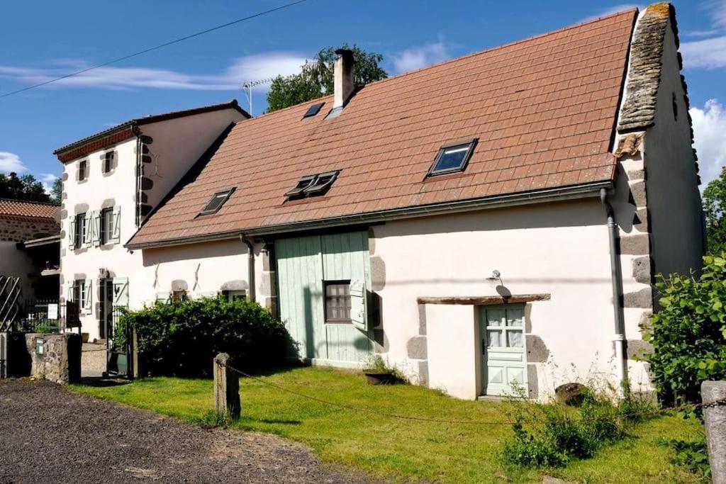 una antigua casa blanca con techo rojo en Maison d'Hôtes à Saint Nectaire Chez MamBillig en Saint-Nectaire