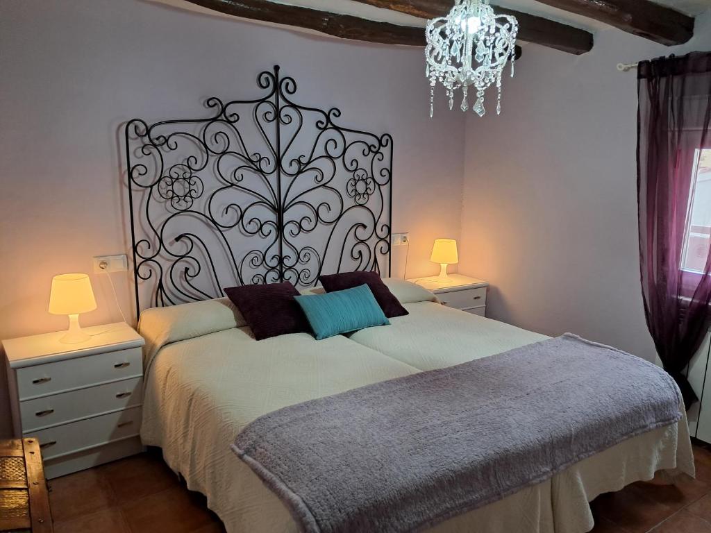 MunébregaにあるRuta del Agua Casa Completa 4 hab al lado Monasterio de Piedraのベッドルーム1室(ベッド1台、ナイトスタンド2台、シャンデリア付)
