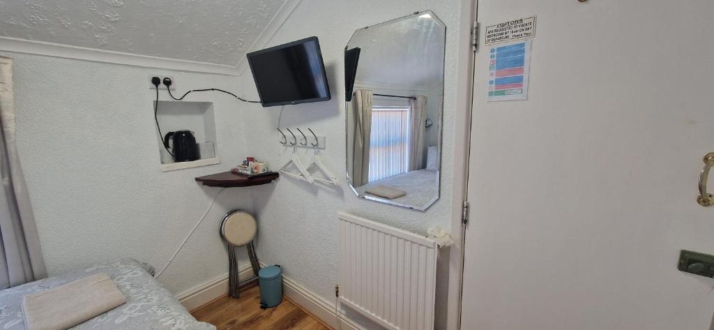 Cette chambre comprend un miroir, un lit et une télévision. dans l'établissement Happi Hotel and Spa, à Blackpool