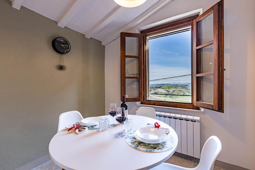 une salle à manger avec une table et des chaises blanches ainsi qu'une fenêtre dans l'établissement La Kasetta, à Terricciola