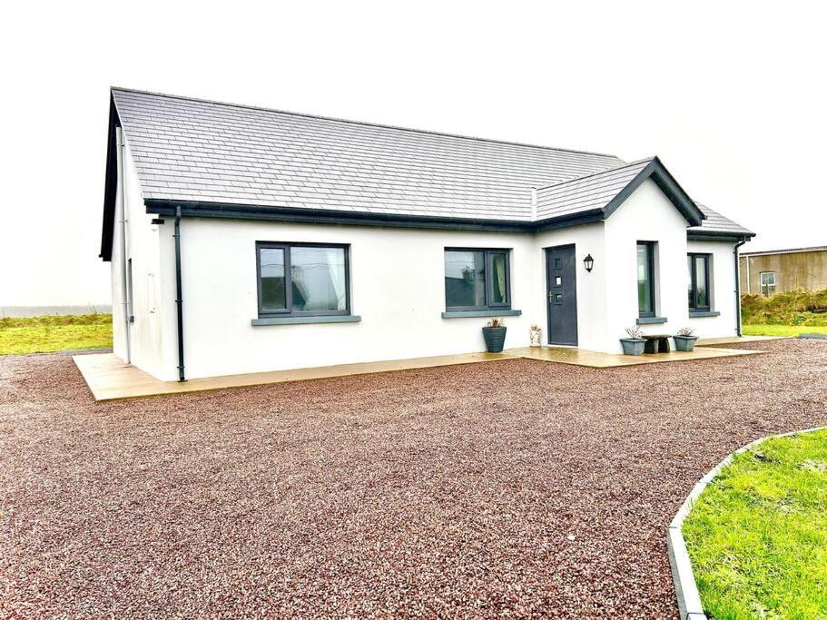 a white house with a gravel driveway at Portmagee Paradise in Portmagee