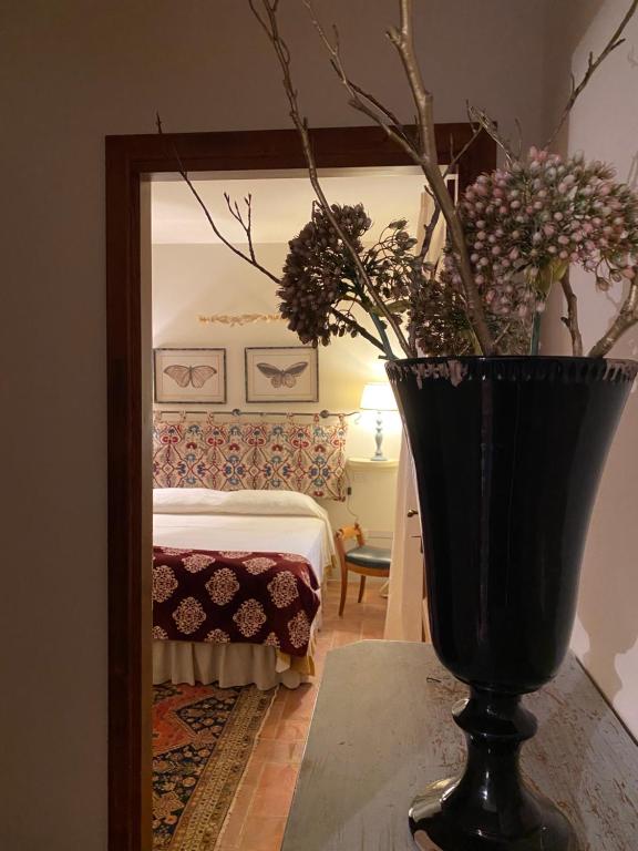 a black vase with flowers in front of a mirror at Il Borghetto Andrea Tafi in Lamporecchio