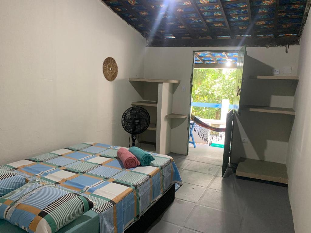 een slaapkamer met een bed in een kamer met een raam bij Despertamar- Hospedagem em Calhetas in Cabo de Santo Agostinho