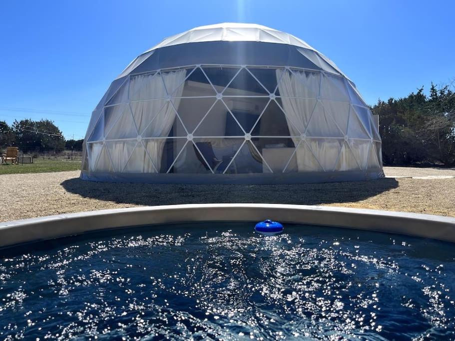 una cúpula con una bola azul en un charco de agua en Dome Sweet Dome, en Lampasas