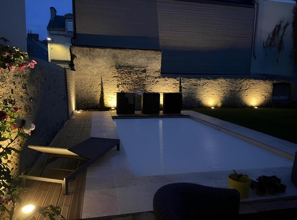 a backyard with a pool at night with lights at Le Serengeti - Piscine - 7pers - Circuit Bugatti - Rêve au Mans in Le Mans