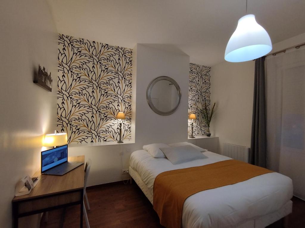 a bedroom with a bed and a desk with a mirror at The Originals Access, Hotel Le Canter Saumur in Saumur