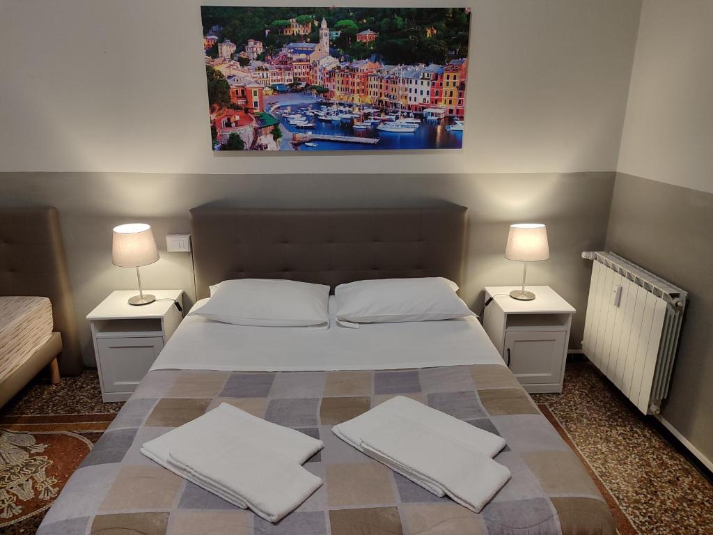 a bedroom with a large bed with two nightstands and two lamps at Guesthouse La Briosa Nicole in Genoa