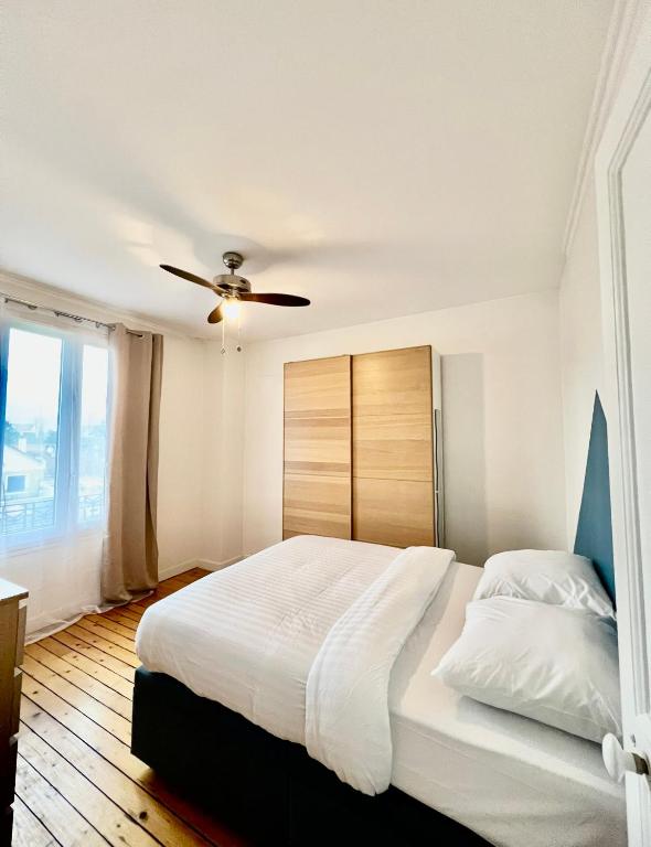 une chambre avec un grand lit avec un ventilateur de plafond dans l'établissement Maison Disney Paris 7 pers Jardin Privé JO24, à Vaires-sur-Marne