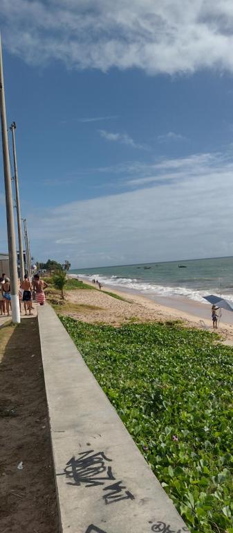 a sidewalk next to a beach with the ocean at Apartamento com vista para o mar in Conde