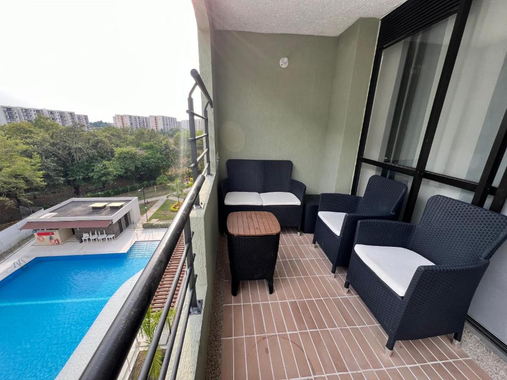 een balkon met stoelen en een zwembad in een gebouw bij Hermoso Apartamento moderno y vacacional in Ricaurte