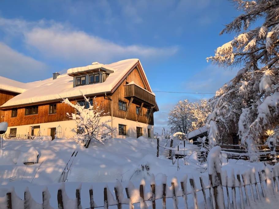 Obergünzburg的住宿－Willkommen im Alpen Relax，围栏前的雪覆盖的房子