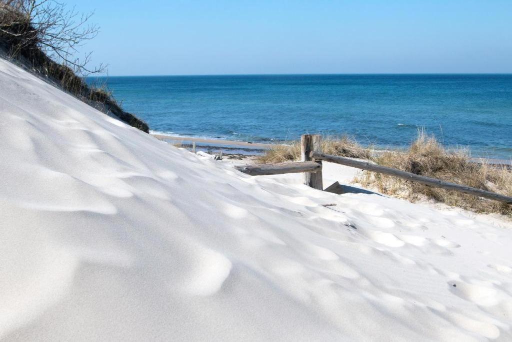 un camino cubierto de nieve junto a la playa en Bungalow MEER ODER WENIGER direkt am Strand, en Dranske