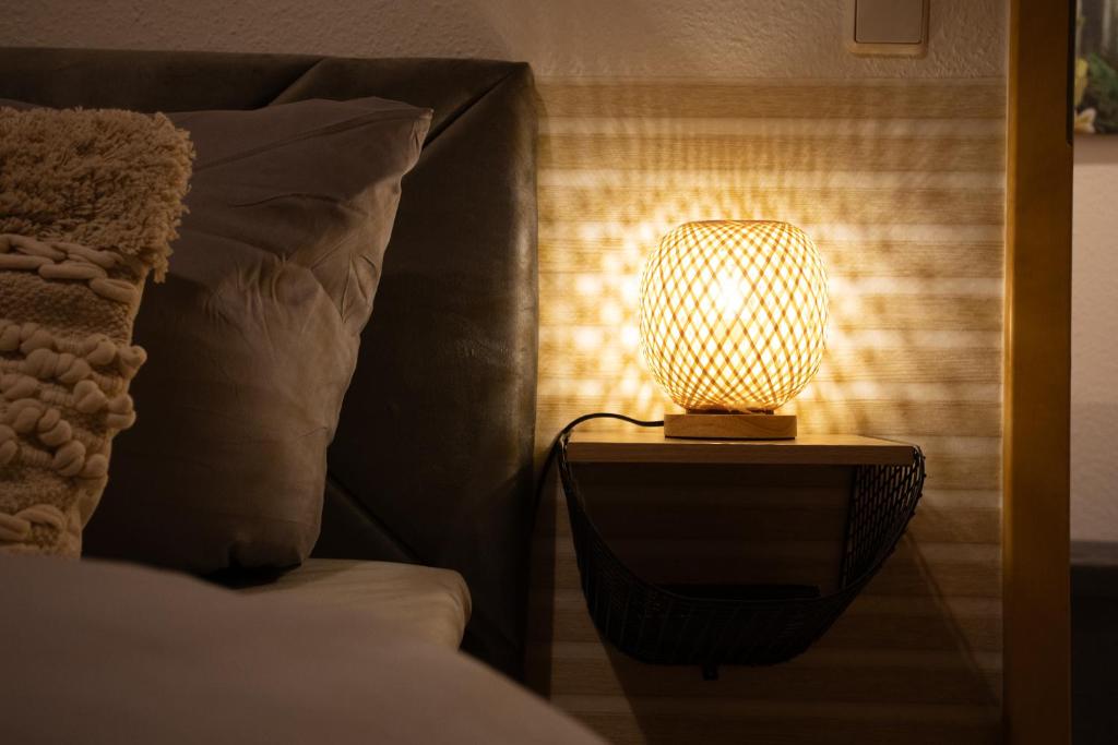 eine Lampe auf einem Nachttisch neben einem Bett in der Unterkunft Koala Apartment mit 500 Mbit's WLAN und Balkon in Leipzig