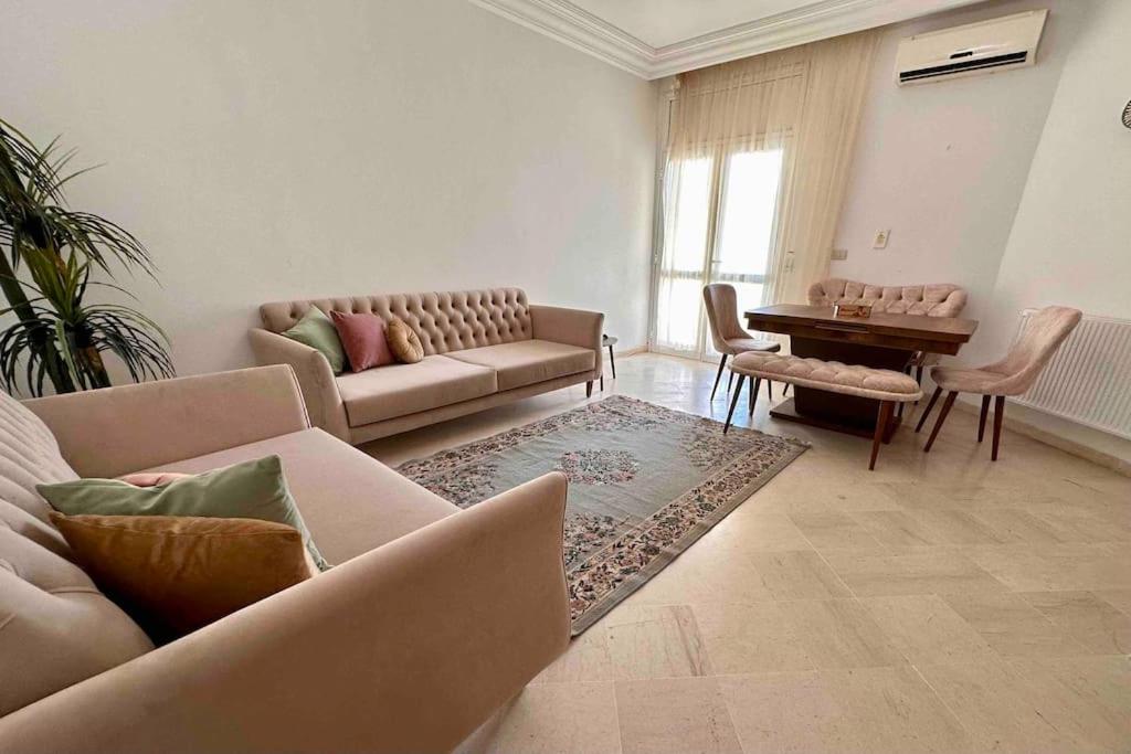 ein Wohnzimmer mit einem Sofa und einem Tisch in der Unterkunft Appartement fonctionnel proche de tout in Tunis