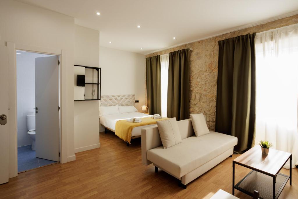 a hotel room with a bed and a couch at Estudio en Villanubla in Villanubla