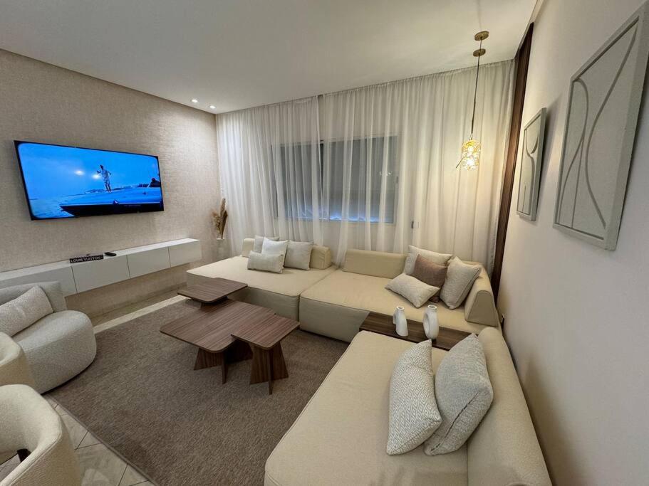 a living room with a couch and a tv at Appartement à 10 min de la mer à pied in Casablanca