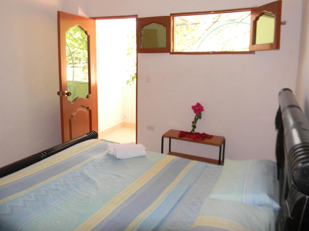 um quarto com uma cama e uma flor sobre uma mesa em HostalNativo em Taganga