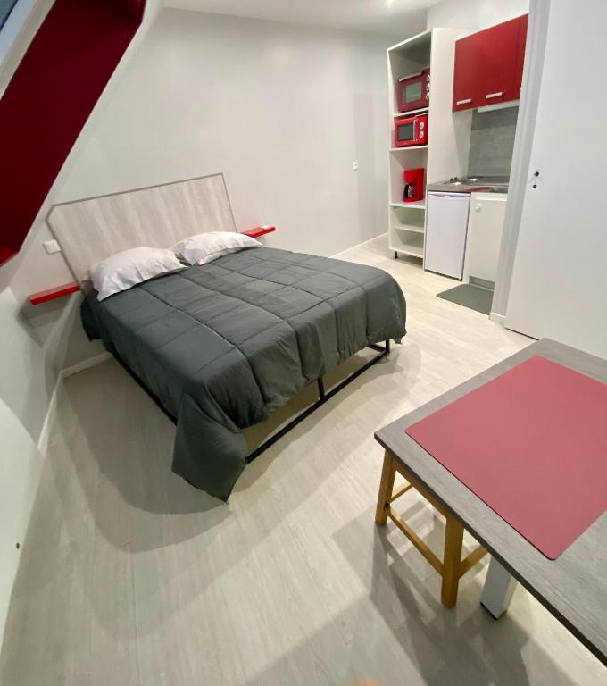 une chambre avec un lit et une table dans une pièce dans l'établissement studio indépendant 800 m de la gare du Mans, au Mans