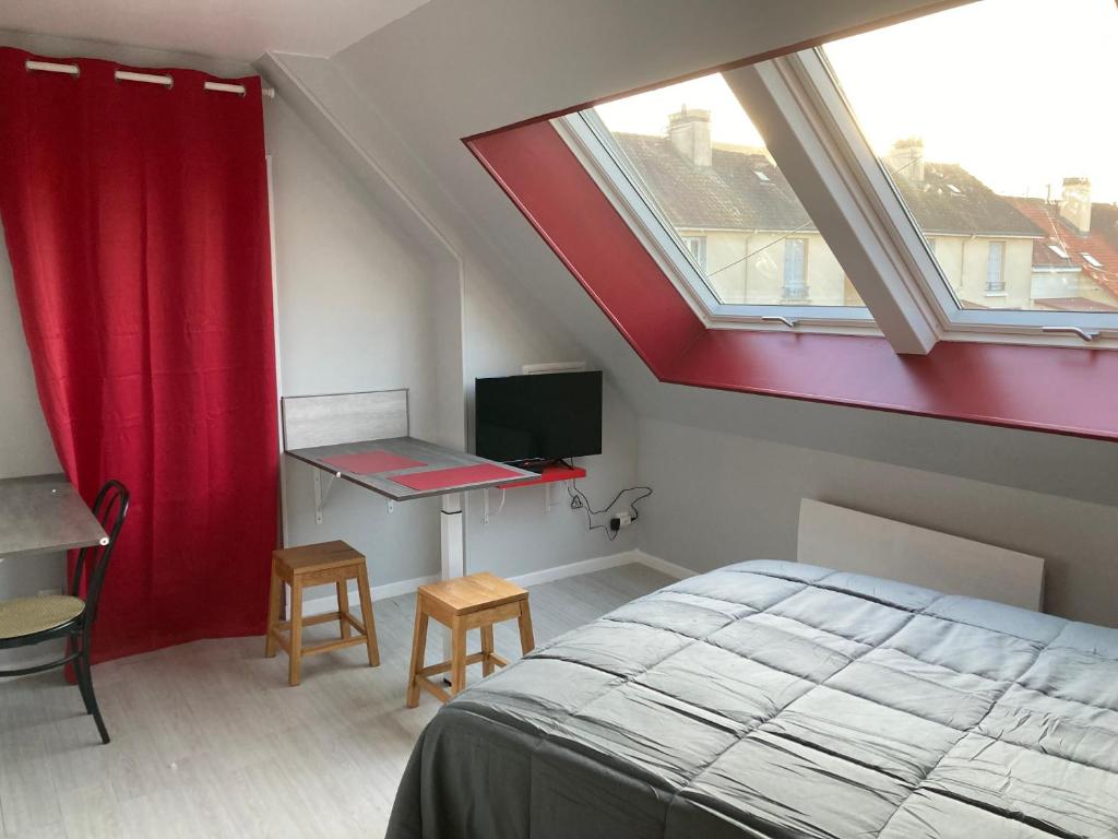 a bedroom with a bed and a desk and a window at studio indépendant 800 m de la gare du Mans in Le Mans
