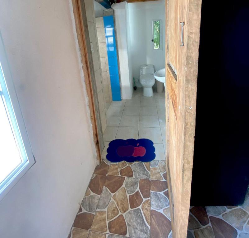 a bathroom with a door open to a toilet at Cabaña La Punta in Colón