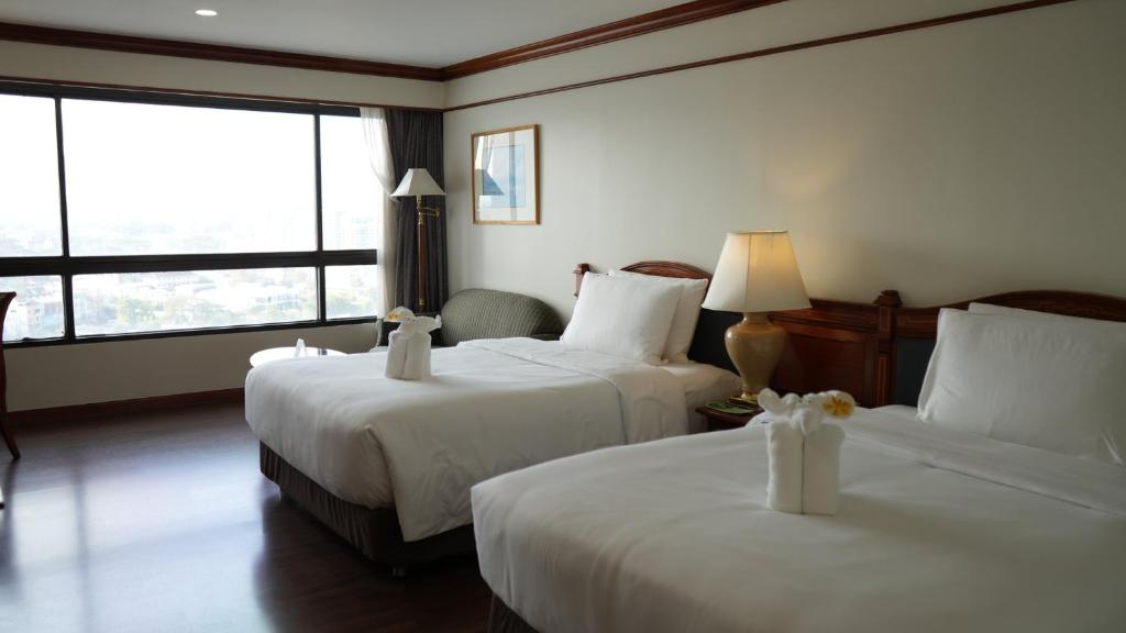 A twin-bedded room has two separate beds, a window wall and a small seating area.