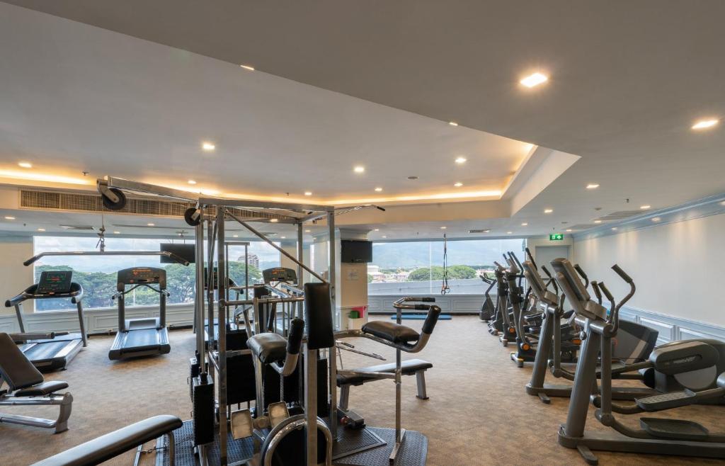 A spacious fitness room with cardio machines, cable equipment and mountain-facing windows.