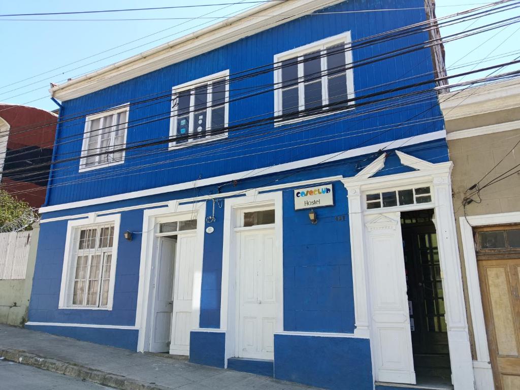 un bâtiment bleu avec des portes blanches dans une rue dans l'établissement Casaclub Hostel, à Valparaíso