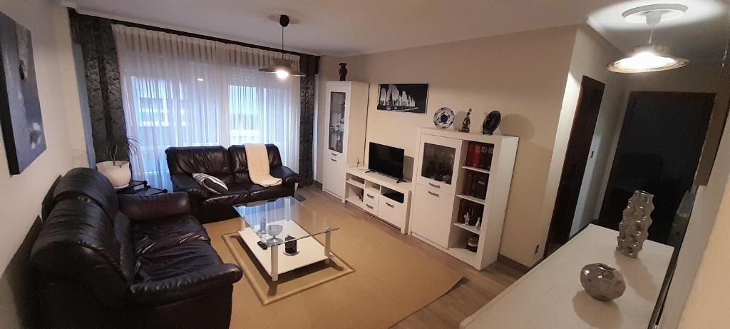 een woonkamer met 2 leren stoelen en een televisie bij Apartamentos Maliayo Villaviciosa in Villaviciosa
