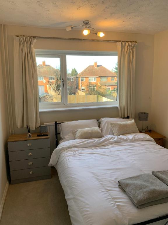 een slaapkamer met een bed en een groot raam bij Adam Guest House in Leicester