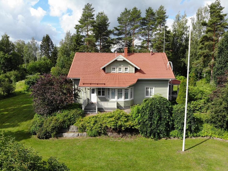 una casa con techo rojo en un patio verde en Villa Kasukkala, en Lappeenranta