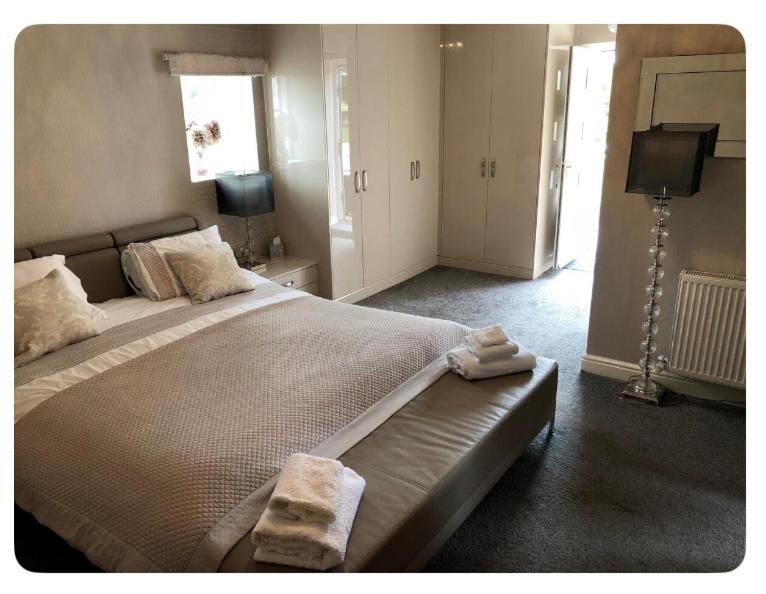 a bedroom with a large bed with towels on it at The Oaks A private room in our home With its own entrance with internal doors locked More suited to quieter guests wanting a peaceful stay in Consett
