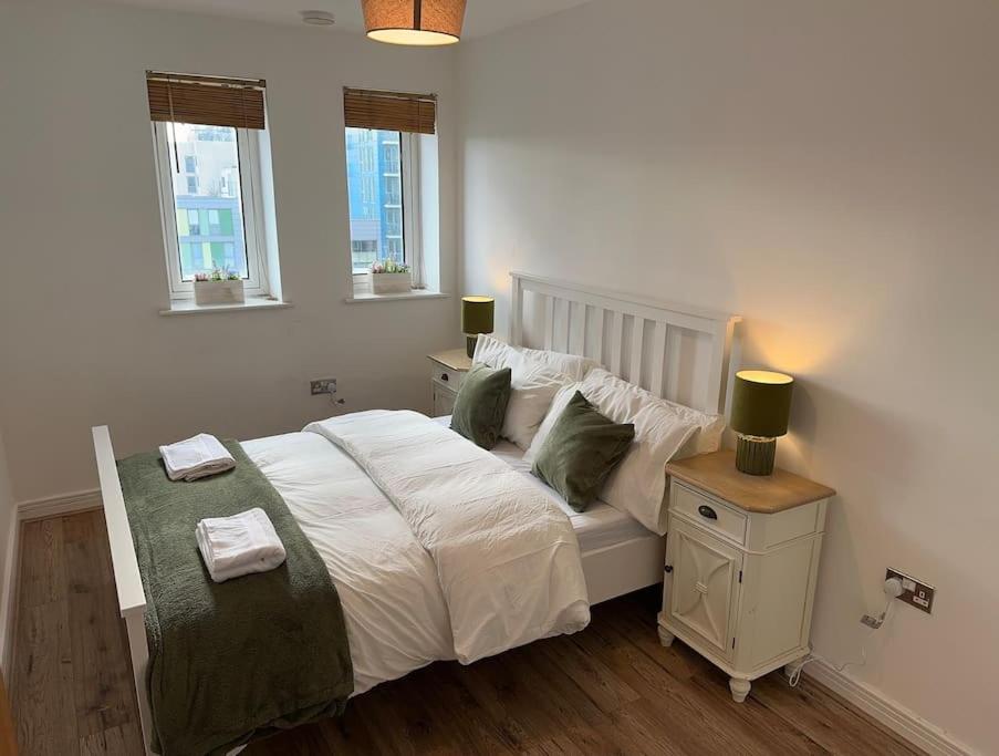a bedroom with a large white bed with two pillows at Stratford Apartment - walk to ABBA Voyage in London
