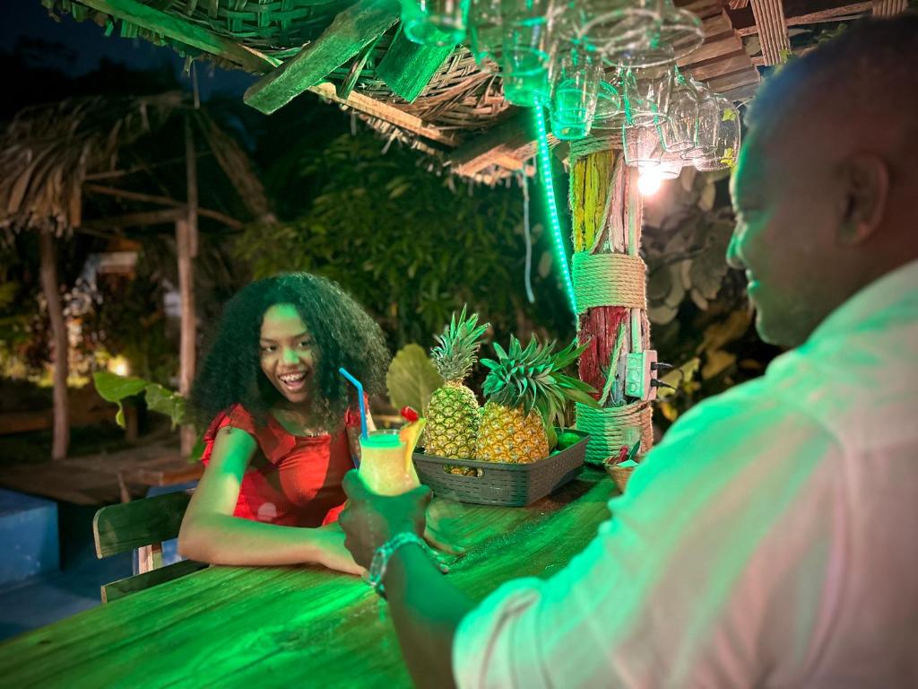 una mujer sentada en una mesa con un hombre en ECO-Hotel Amanecer Tayrona dentro del parque tayrona en El Zaino