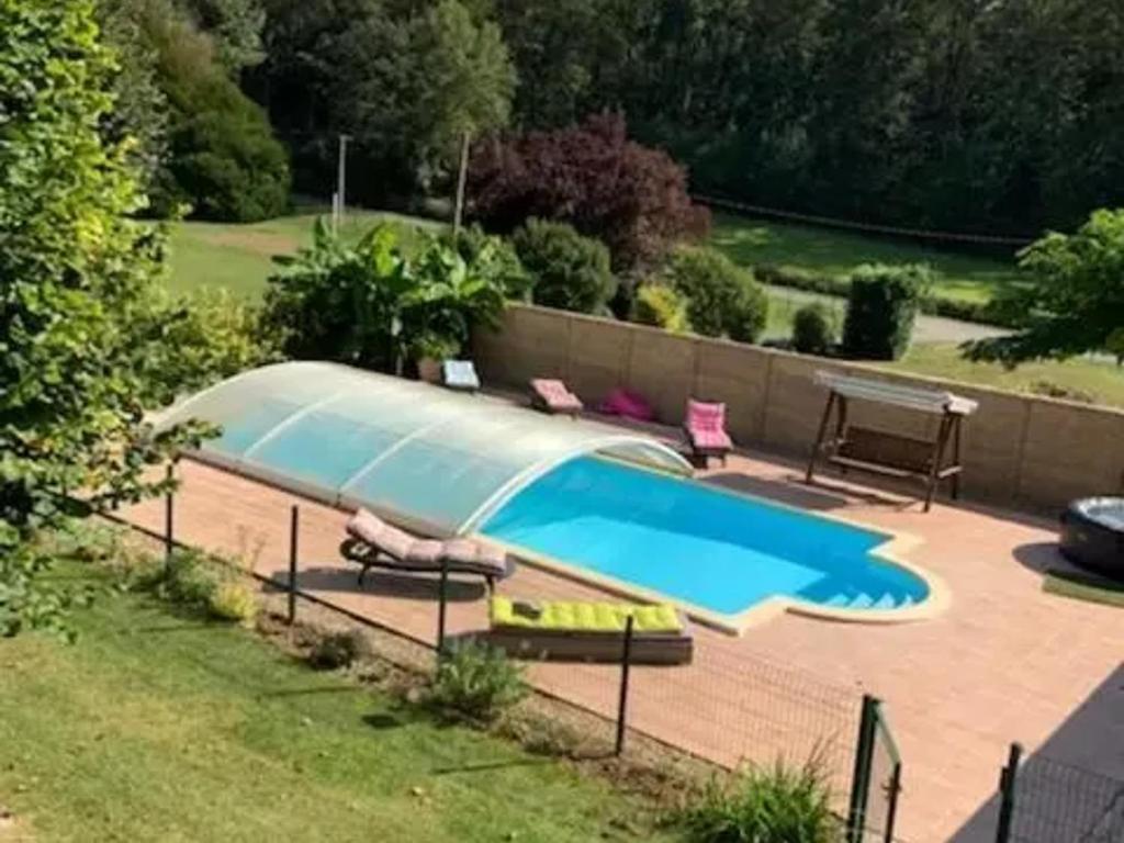 - une piscine dans une cour avec 2 chaises et une clôture dans l'établissement Gîtes de charme avec jacuzzi, piscine chauffée, et activités familiales près du Zoo de Beauval et des Châteaux - FR-1-591-566, à Villentrois