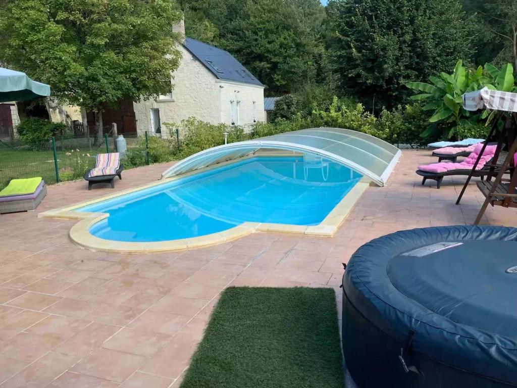 - une piscine dans une cour avec une piscine bleue dans l'établissement Gîte rénové avec piscine chauffée près de Beauval, 10 pers., terrain de sport et nature. - FR-1-591-568, à Villentrois
