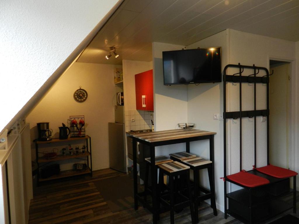 a kitchen with a bar with a tv on the wall at Appartement Le Pleynet, 1 pièce, 3 personnes - FR-1-557A-54 in La Ferrière